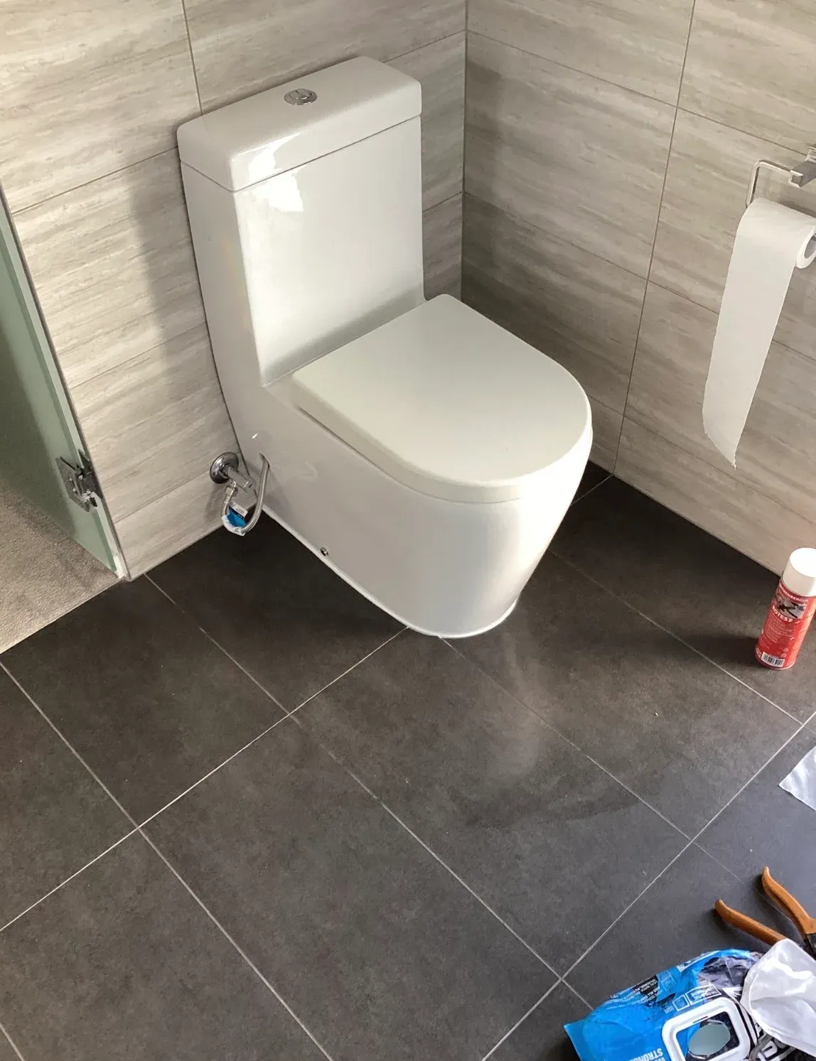 White toilet suite against a tiled bathroom wall