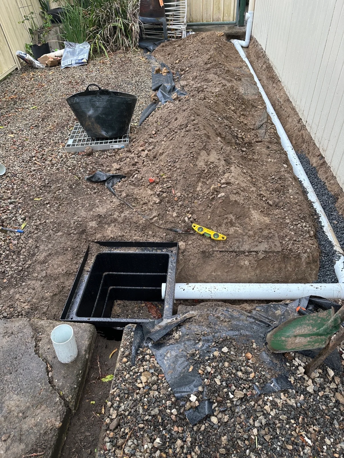 Stormwater pipework connected to a drainage pit beside a building