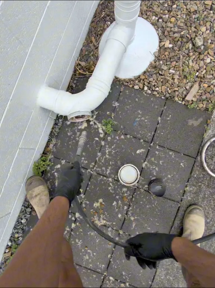 High-pressure jetting hose being used through a drain access point at the Camp Hill property